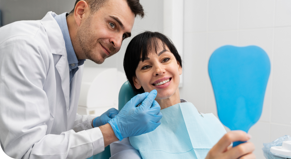 Dentist-looking-at-mirror-on-smiling-patient's-hand.